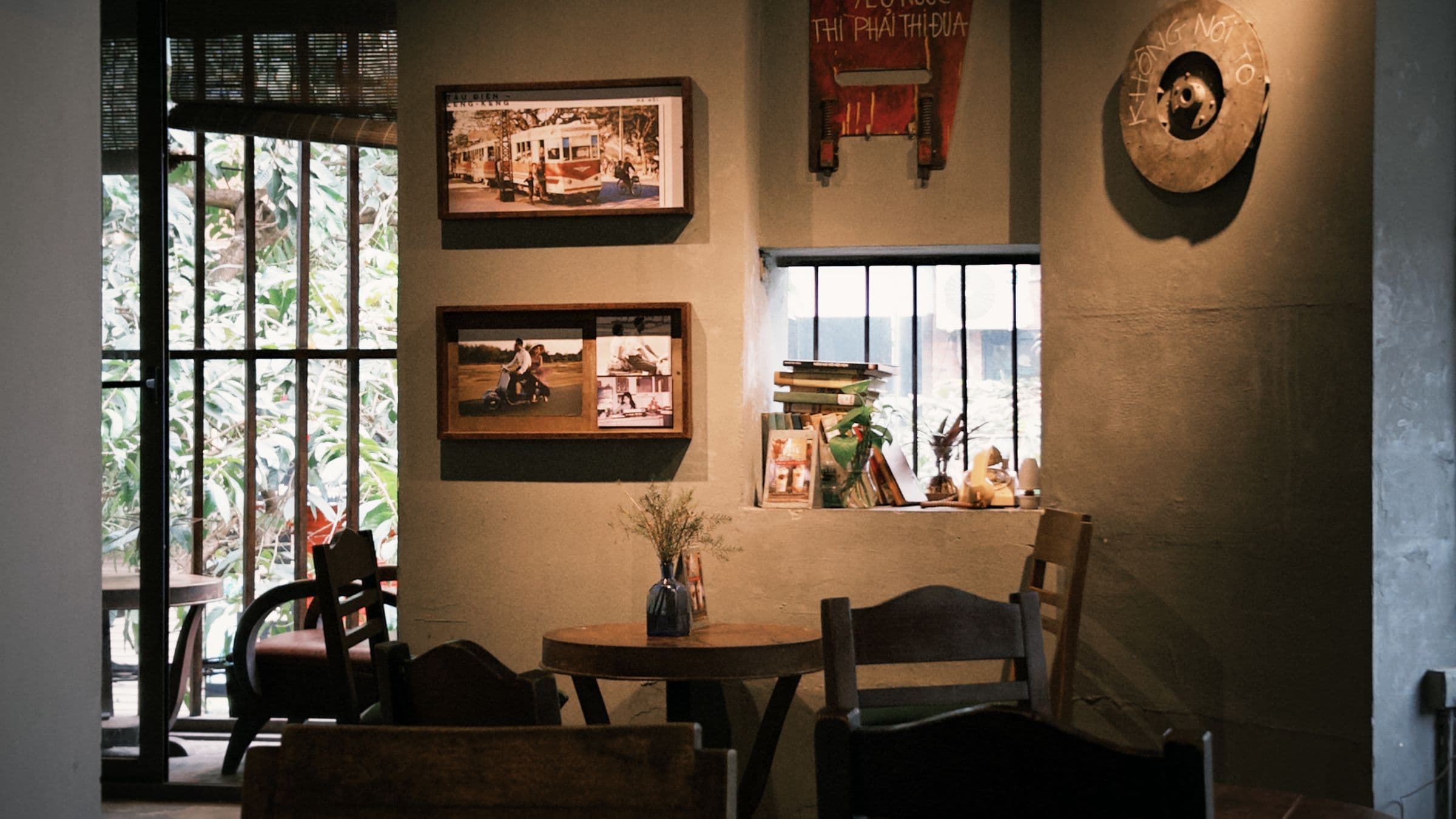 Warm, sunlit interior of a small coffee shop with mismatched wooden seating